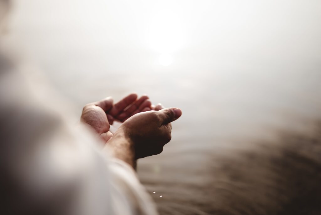 High angle shot of Jesus Christ holding water with his palms